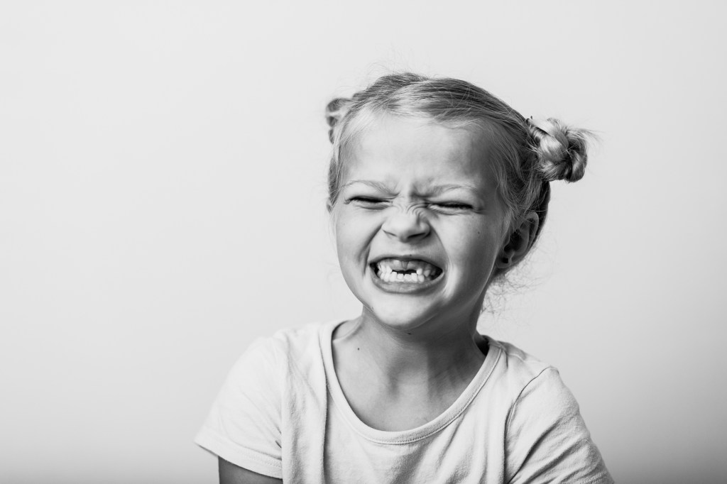7 Year old first grade girl laughing in a fine art school portrait

